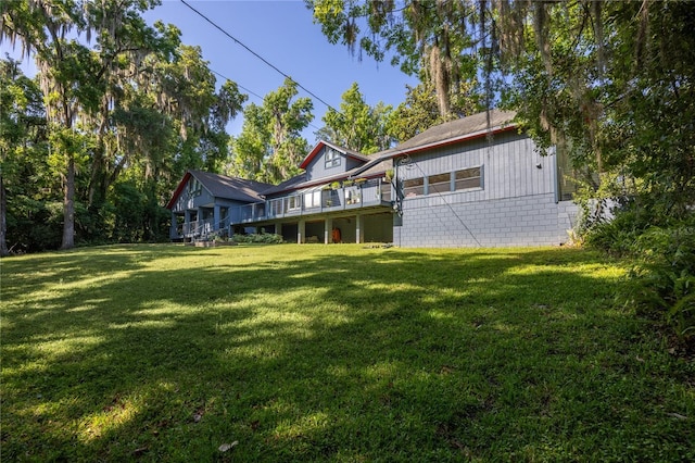 back of house featuring a deck and a yard