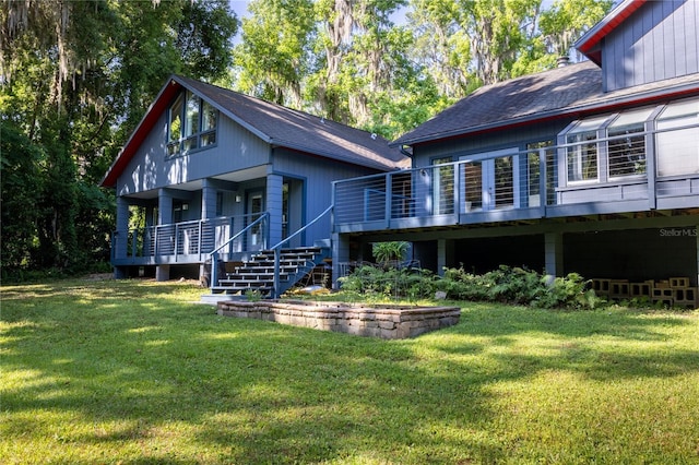 rear view of house featuring a yard and stairway