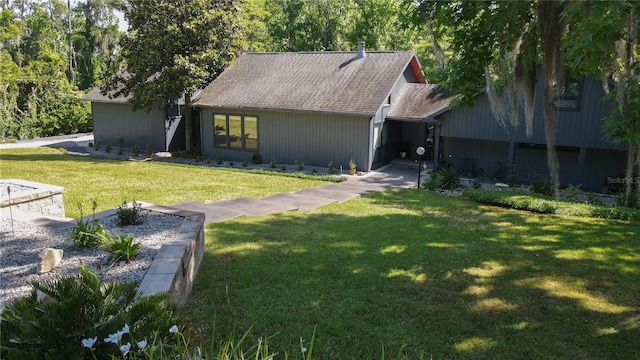 view of front of house with roof with shingles and a front lawn