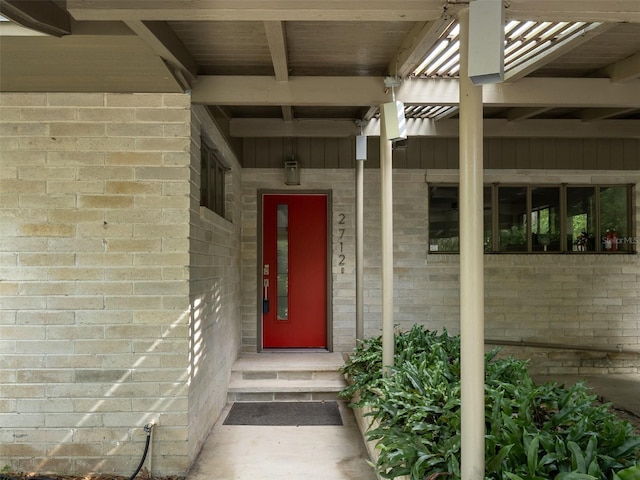 view of exterior entry featuring brick siding