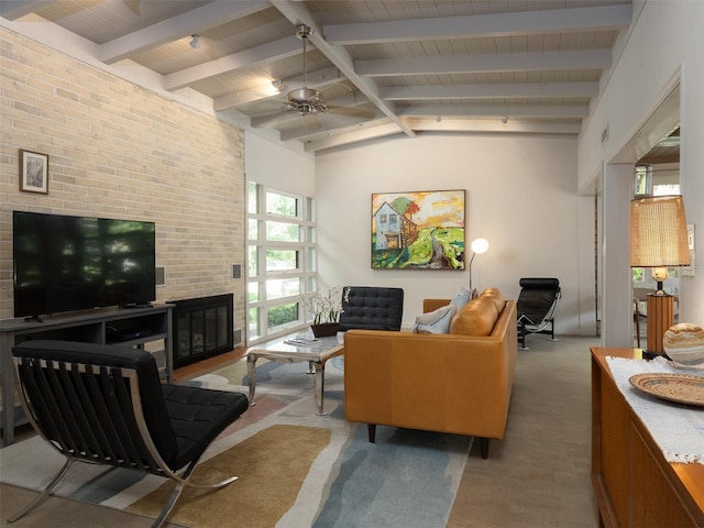 living area featuring vaulted ceiling with beams, visible vents, a glass covered fireplace, ceiling fan, and wooden ceiling