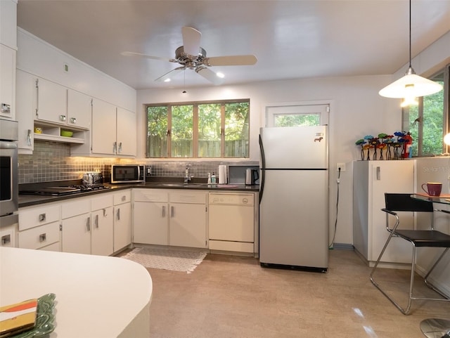 kitchen with dark countertops, plenty of natural light, appliances with stainless steel finishes, and backsplash