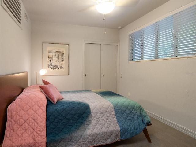 carpeted bedroom featuring a ceiling fan, a closet, visible vents, and baseboards