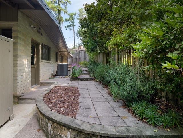 view of patio with central air condition unit and fence