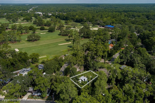 drone / aerial view with view of golf course and a wooded view