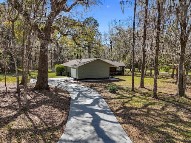 view of home's community featuring a garage, a lawn, and concrete driveway