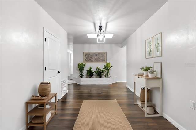 interior space featuring baseboards and dark wood finished floors