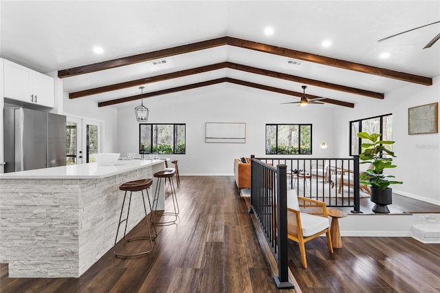 kitchen featuring vaulted ceiling with beams, dark wood-style flooring, visible vents, and freestanding refrigerator