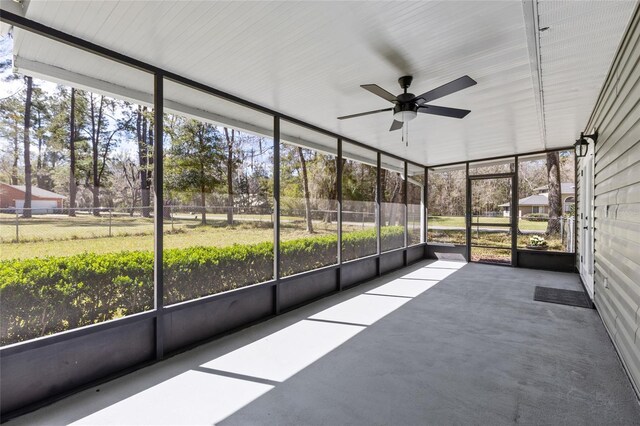 unfurnished sunroom featuring ceiling fan