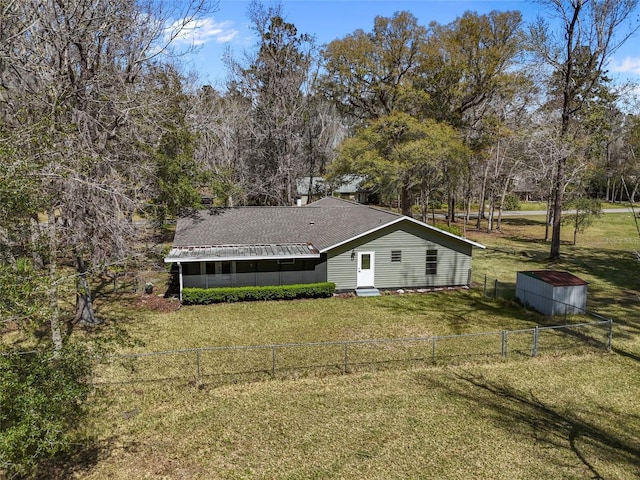 back of property with a lawn, fence private yard, and a sunroom