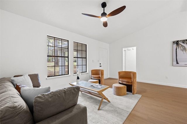 living room with lofted ceiling, wood finished floors, a ceiling fan, and baseboards