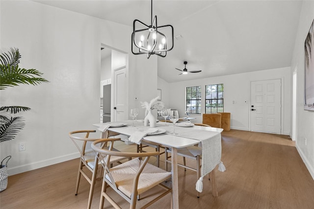 dining space with lofted ceiling, light wood-style flooring, baseboards, and a ceiling fan