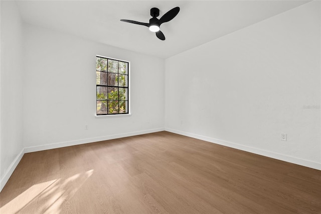 spare room featuring a ceiling fan, baseboards, and wood finished floors