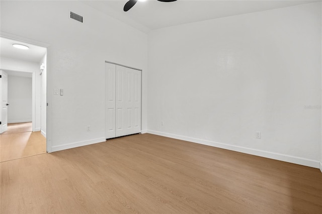 empty room with light wood-style floors, visible vents, ceiling fan, and baseboards