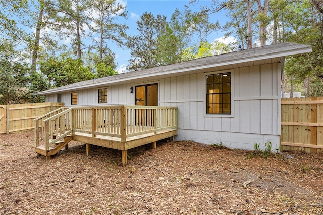 back of house with fence and a wooden deck