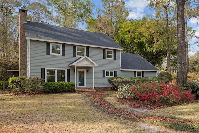 colonial house with a chimney and a front yard