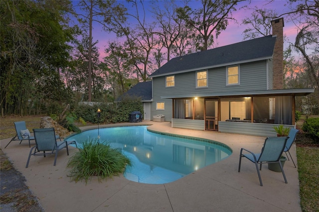 outdoor pool featuring a patio area and a sunroom