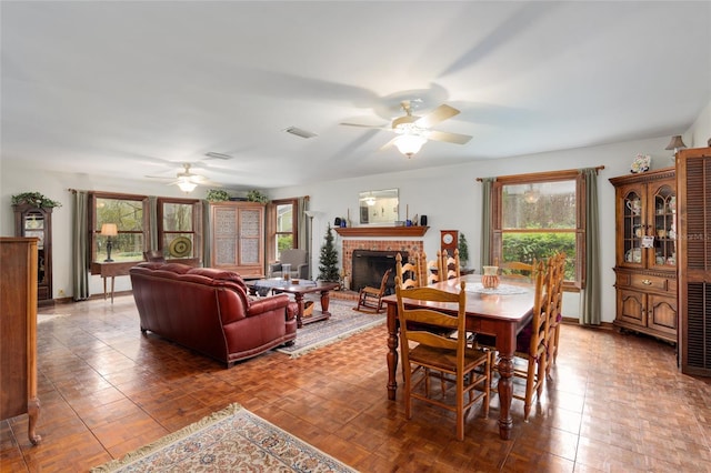 dining area with visible vents, a fireplace, and a ceiling fan