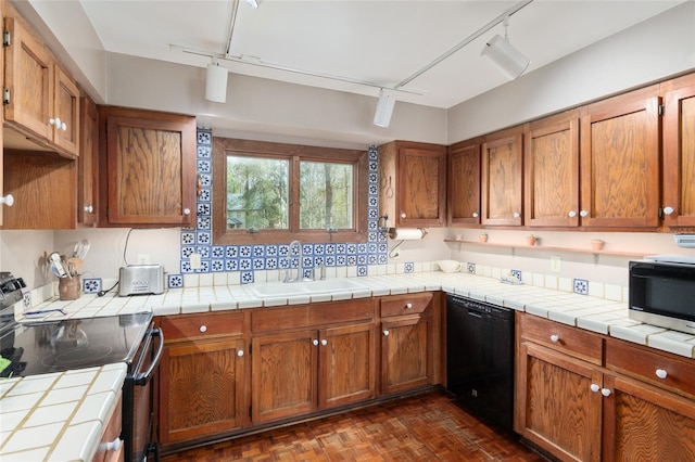 kitchen featuring black appliances, brown cabinets, and a sink