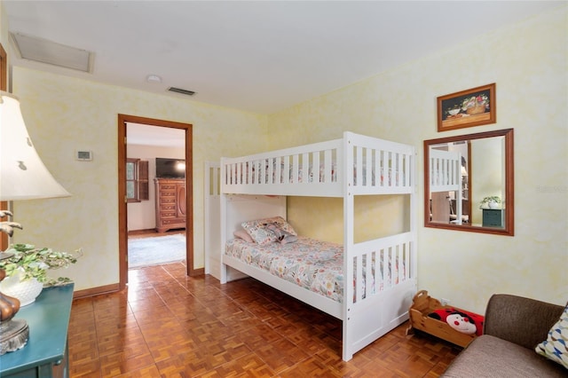 bedroom featuring attic access, visible vents, and baseboards