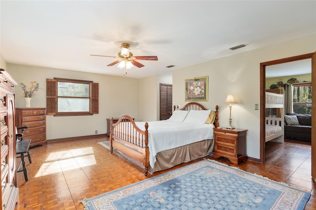 bedroom featuring ceiling fan, visible vents, and baseboards