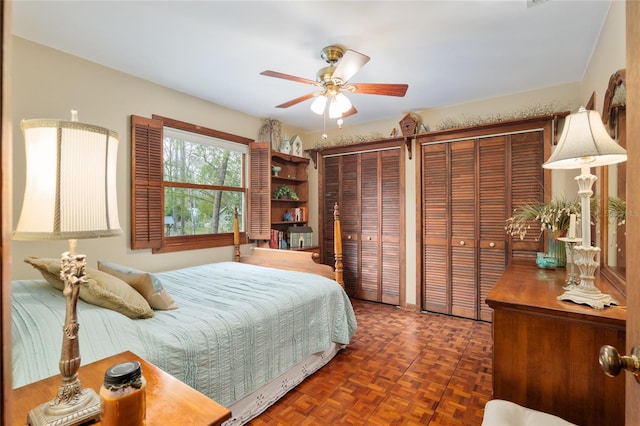 bedroom featuring multiple closets and a ceiling fan