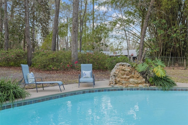 outdoor pool with a patio area and fence