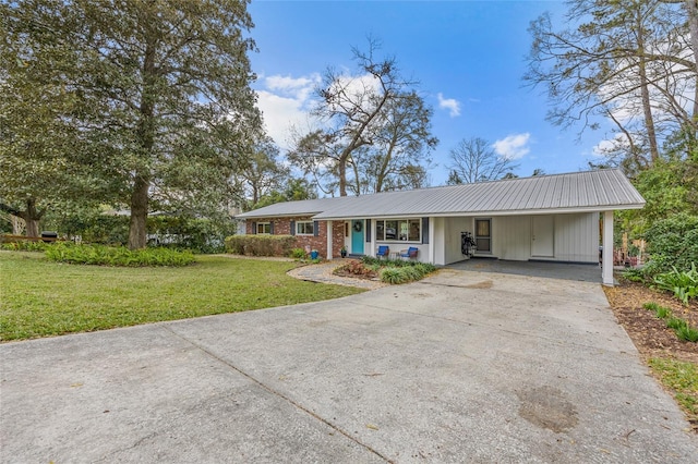 ranch-style house featuring brick siding, concrete driveway, a front lawn, and an attached carport