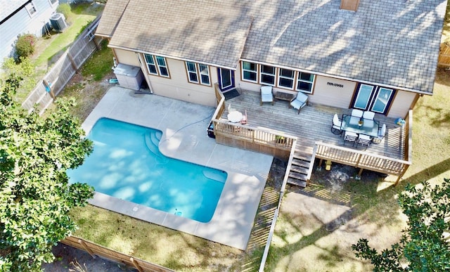 exterior space featuring a deck, outdoor dining space, a fenced backyard, and a fenced in pool