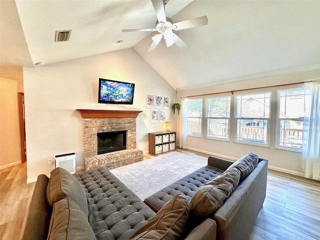 living area featuring a fireplace, wood finished floors, visible vents, and baseboards