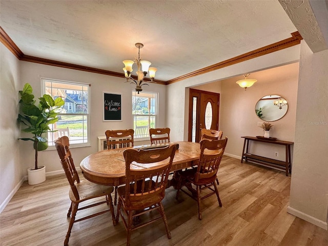 dining room featuring ornamental molding, baseboards, light wood finished floors, and an inviting chandelier