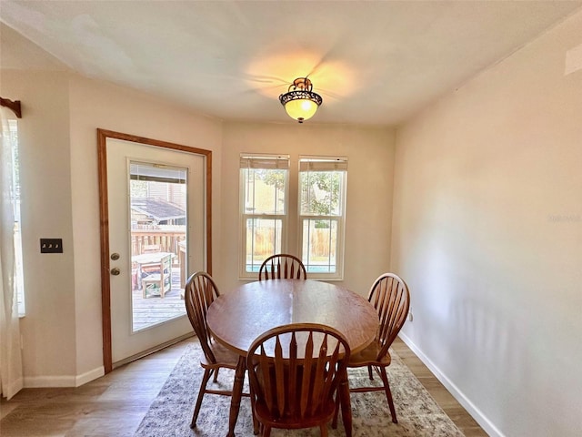 dining space featuring baseboards and wood finished floors