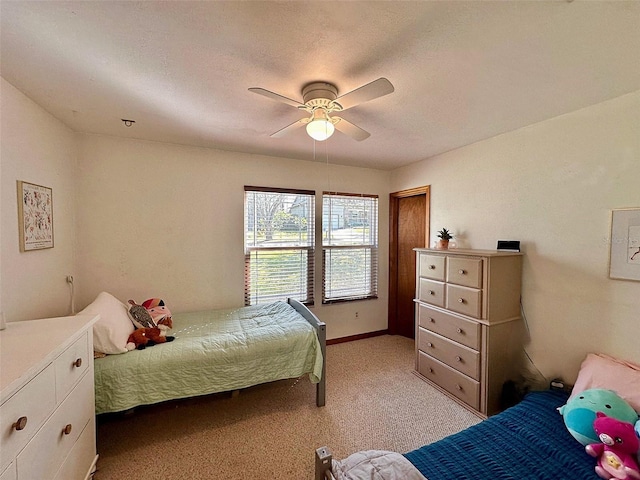 bedroom with a ceiling fan, light carpet, and a textured ceiling