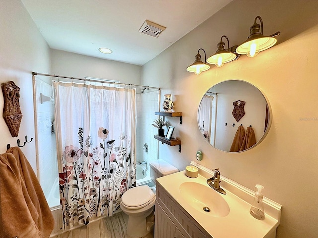 bathroom with visible vents, toilet, wood finished floors, shower / tub combo with curtain, and vanity