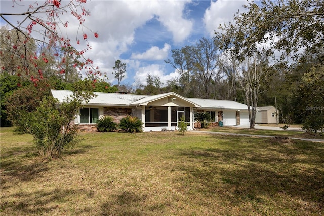 ranch-style home with a front lawn, brick siding, a sunroom, and metal roof