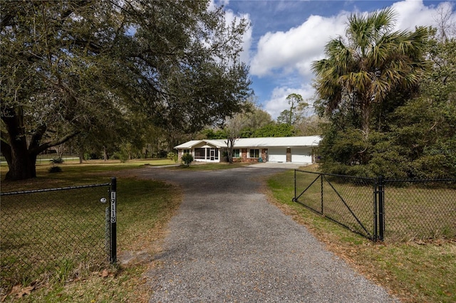 ranch-style house with a garage, driveway, a front yard, and fence