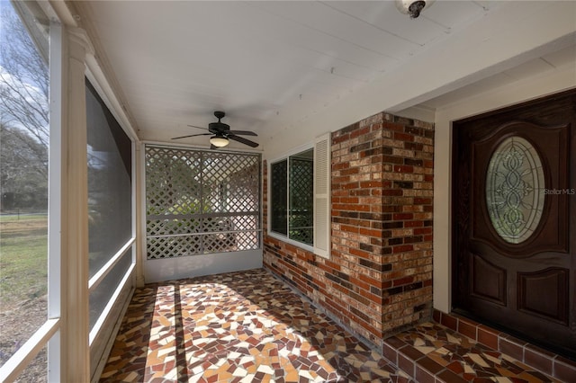 doorway to property featuring brick siding and ceiling fan