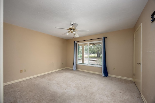 empty room with light carpet, ceiling fan, and baseboards