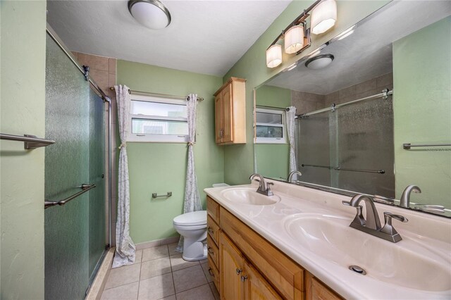 full bath featuring a shower stall, tile patterned floors, and a sink