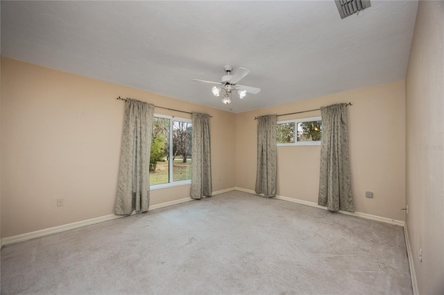 empty room featuring plenty of natural light, visible vents, and carpet