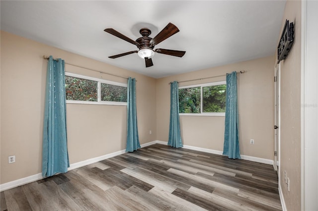 empty room featuring a ceiling fan, wood finished floors, and baseboards