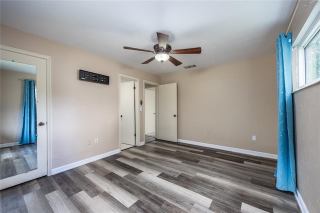 unfurnished bedroom featuring visible vents, ceiling fan, baseboards, and wood finished floors