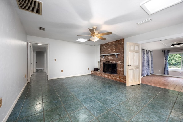 unfurnished living room featuring visible vents, a fireplace, baseboards, and ceiling fan