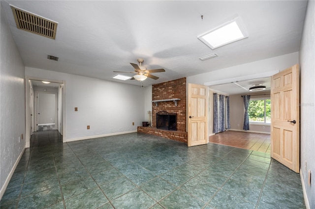 unfurnished living room with visible vents, a fireplace, baseboards, and ceiling fan