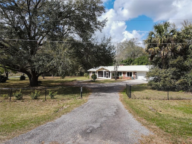 view of front of property with a fenced front yard, driveway, and a front lawn