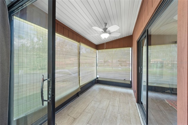 unfurnished sunroom with ceiling fan and vaulted ceiling