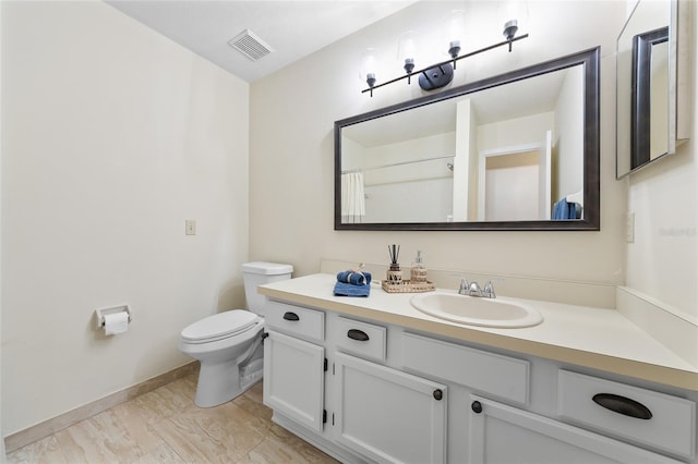 bathroom with toilet, baseboards, visible vents, and vanity