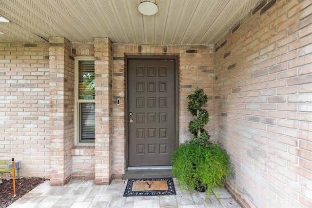 view of exterior entry with brick siding