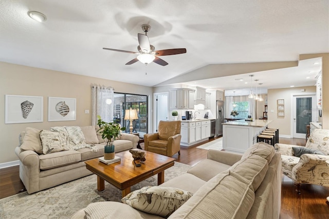 living room featuring lofted ceiling, wood finished floors, a ceiling fan, and baseboards