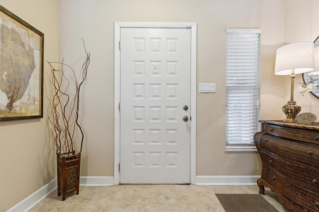 foyer with light tile patterned floors and baseboards